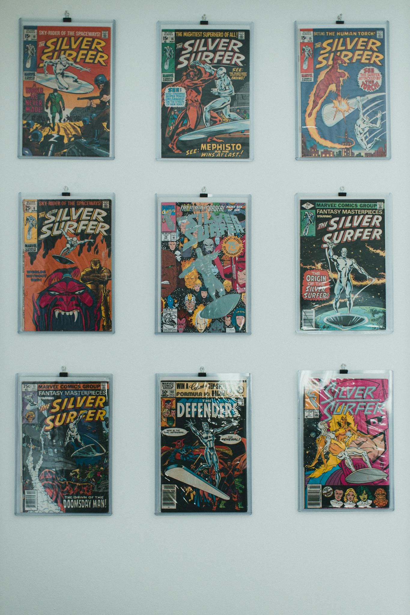 A vibrant wall display featuring a collection of classic Silver Surfer comic books in protective sleeves.